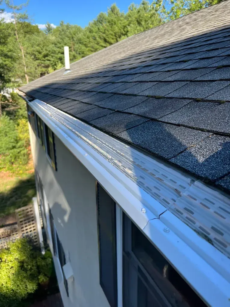 A house with a gutter on the side of it and a roof.