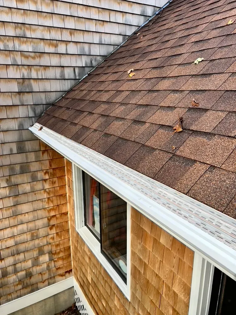 A house with a brown roof and a white gutter.