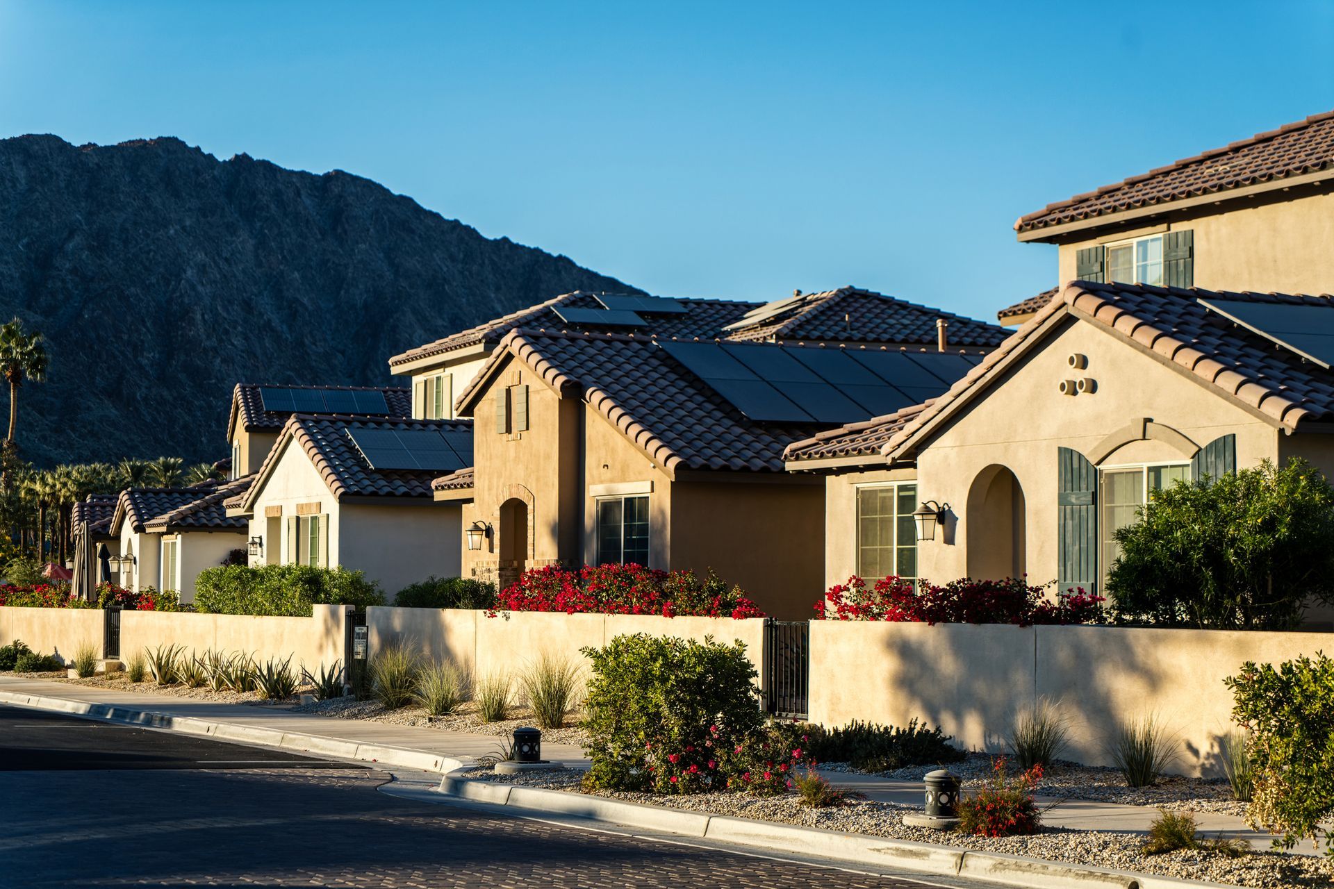 Kitchen with wood cabinets, white appliances, and view into a room. Dark wood-look floor.