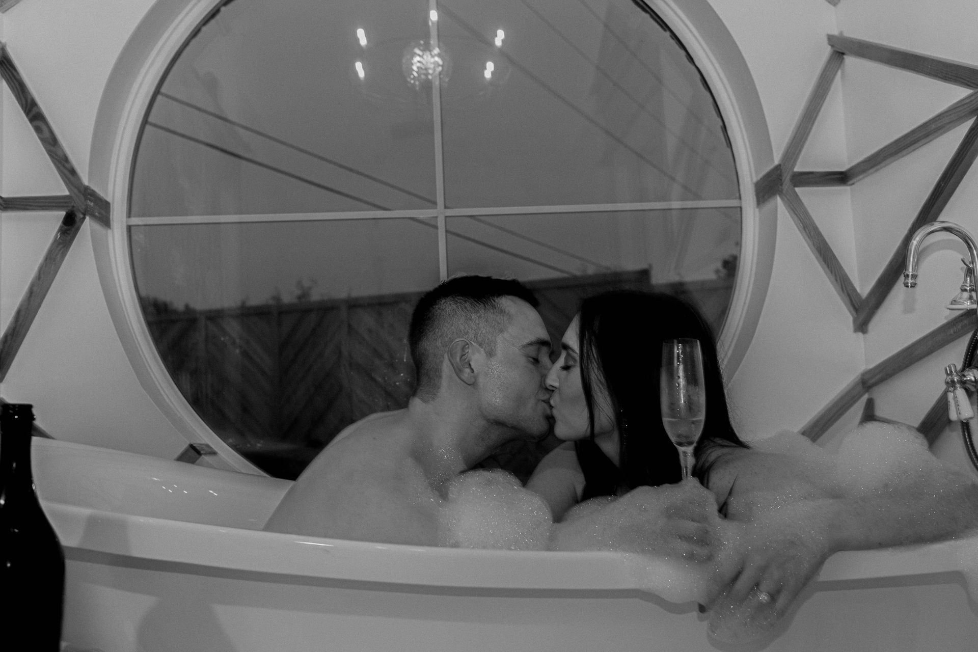 A man and a woman are kissing in a bathtub.