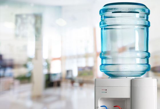 A bottle of water is sitting on top of a water dispenser.