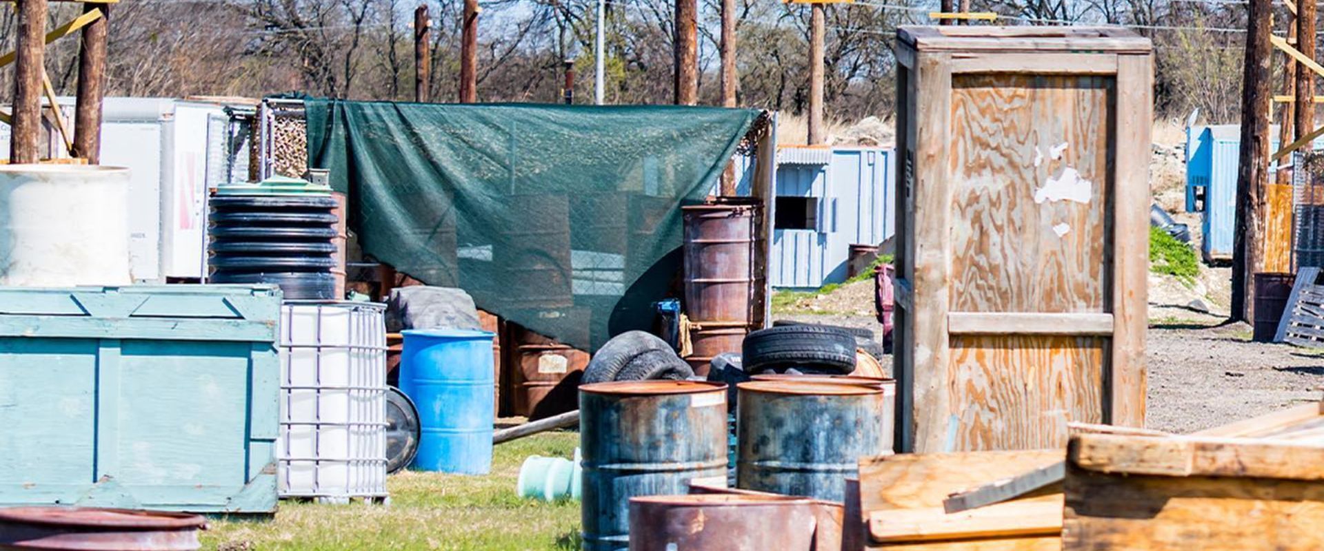 Three men wearing paintball helmets and goggles are standing next to each other.