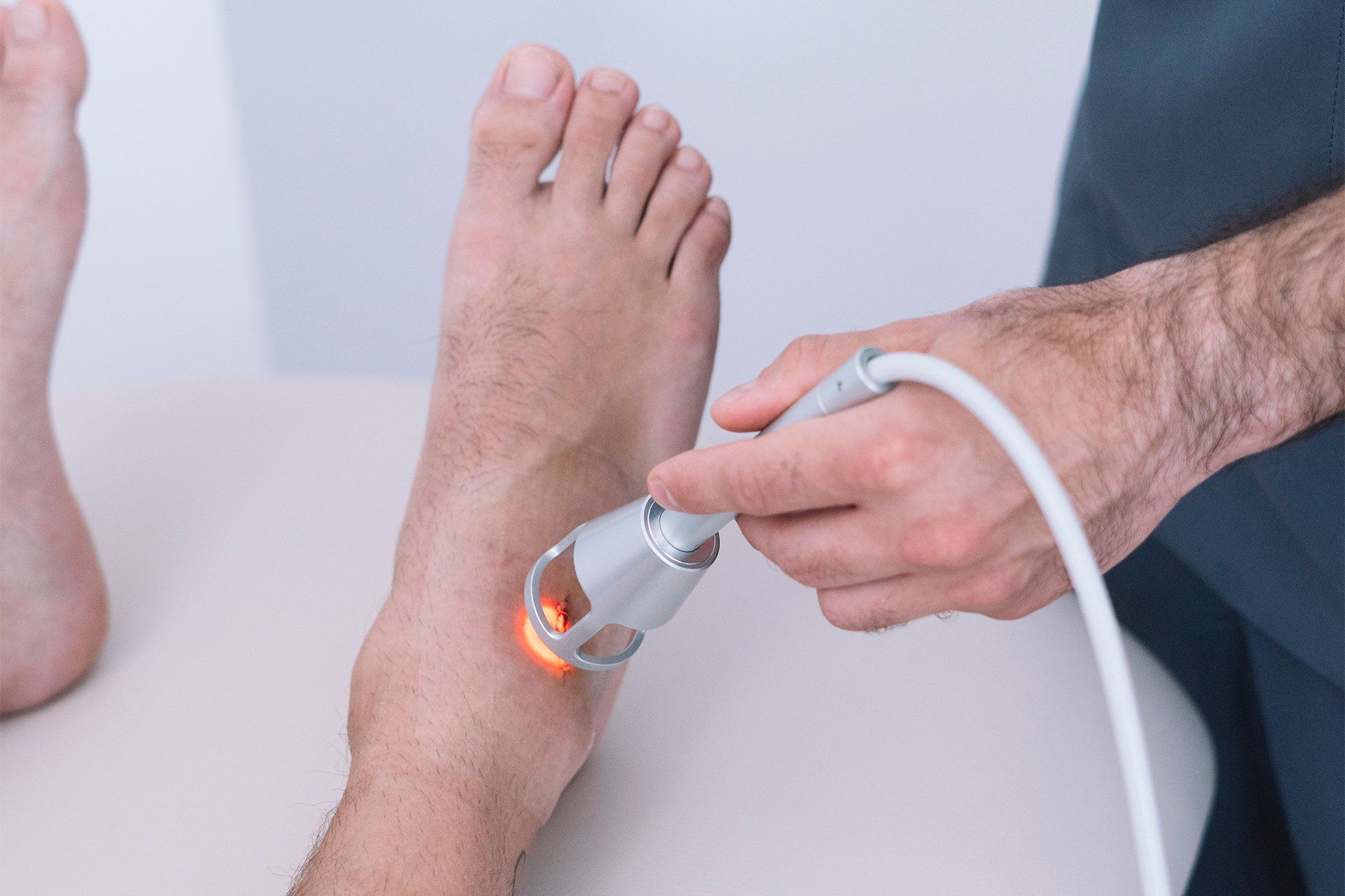 a patient getting low level laser therapy treatment on their foot