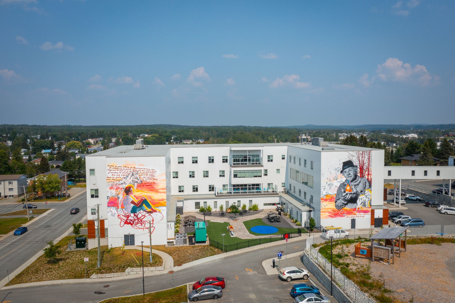 Une vue aérienne d'un grand bâtiment avec une peinture murale sur le côté.