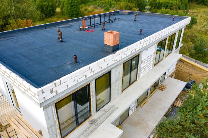 An aerial view of a house under construction with a flat roof.