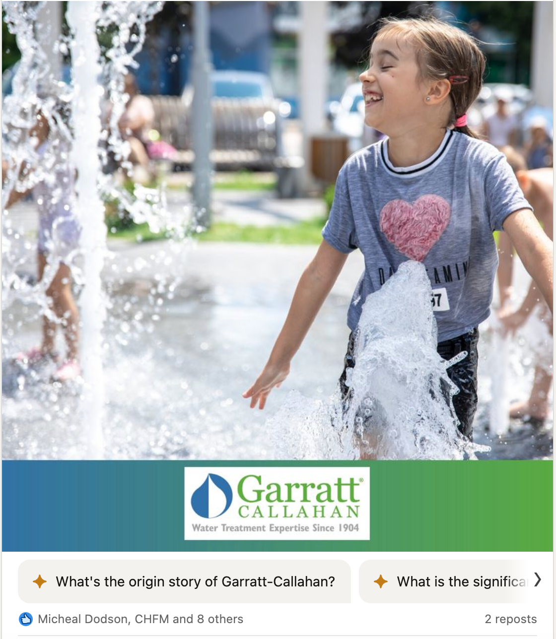 A little girl is playing in a fountain.