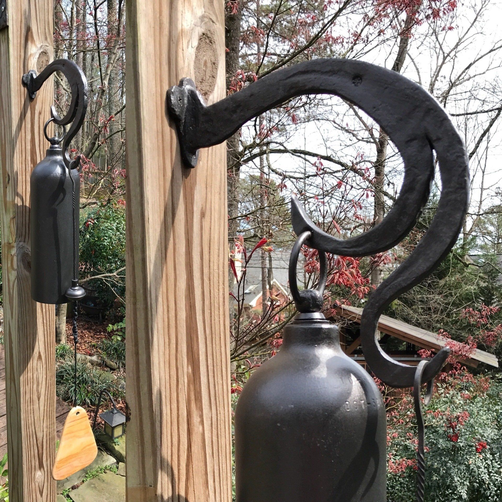 Two bells are hanging on a wooden fence.
