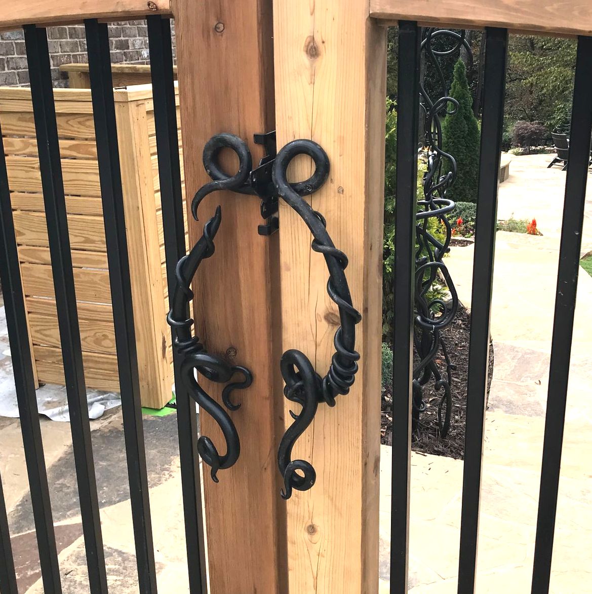 A close up of a wooden gate with wrought iron handles