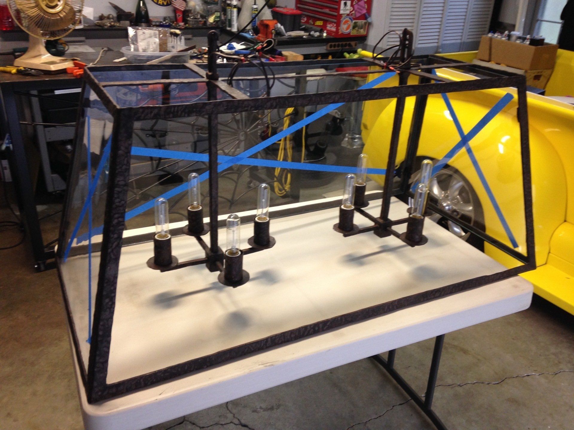 A chandelier is sitting on a table next to a yellow car