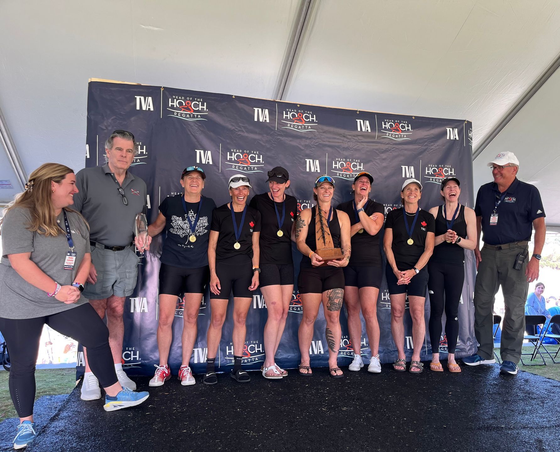 A group of people are posing for a picture in front of a wall that says ' ii ' on it