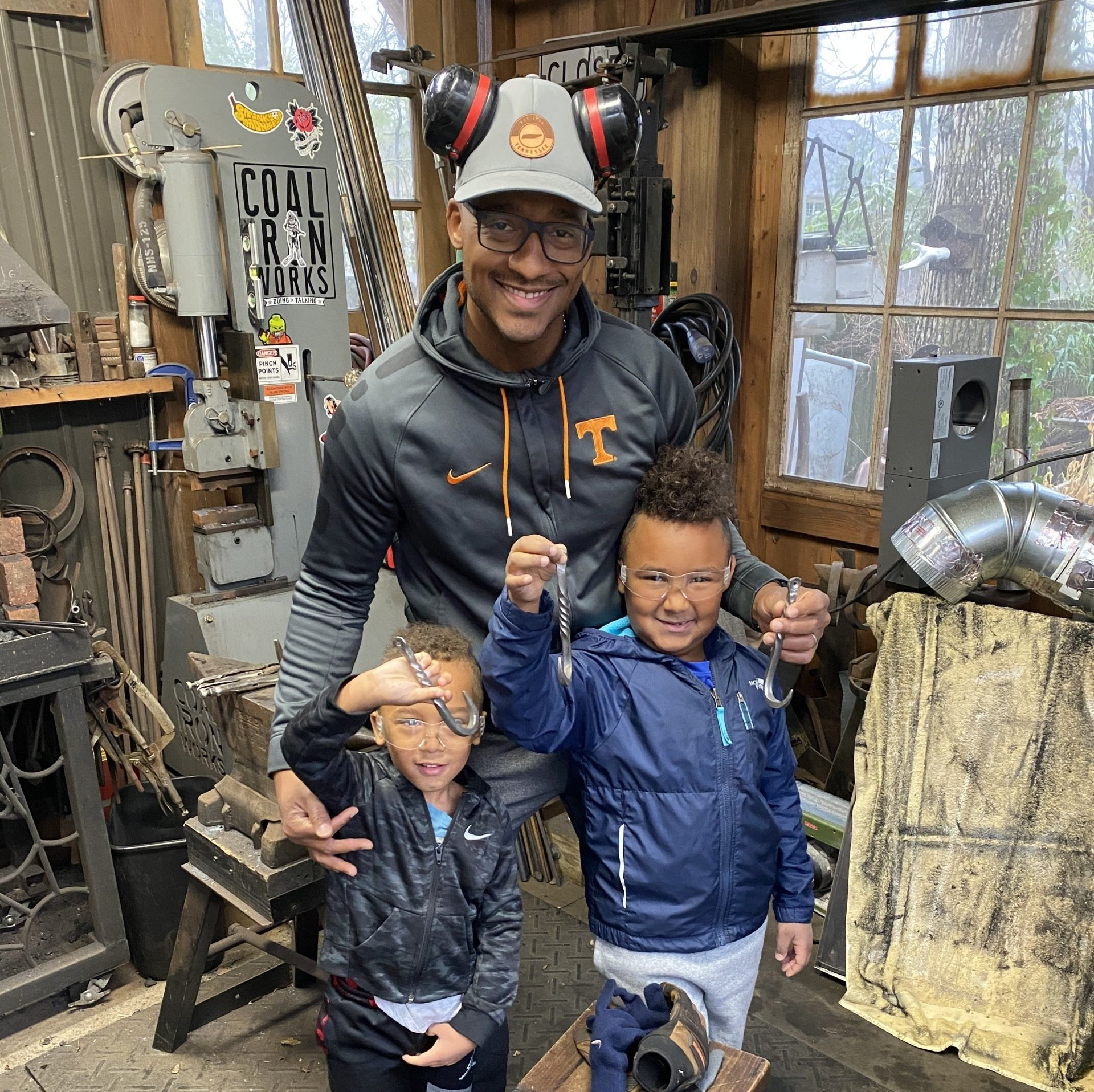 A man and two children are posing for a picture in a workshop.