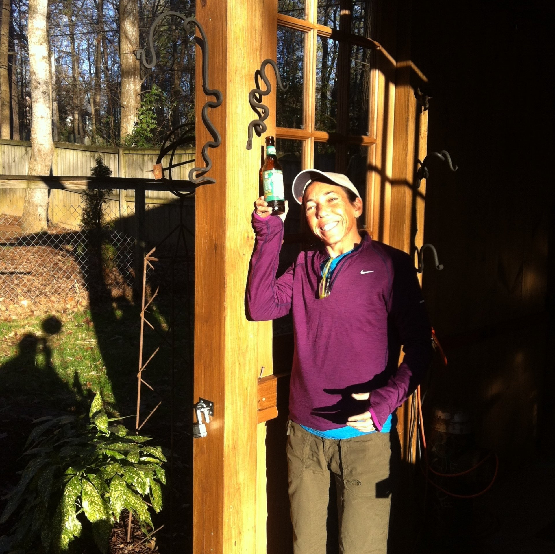 A guest in a purple shirt is holding a bottle of beer