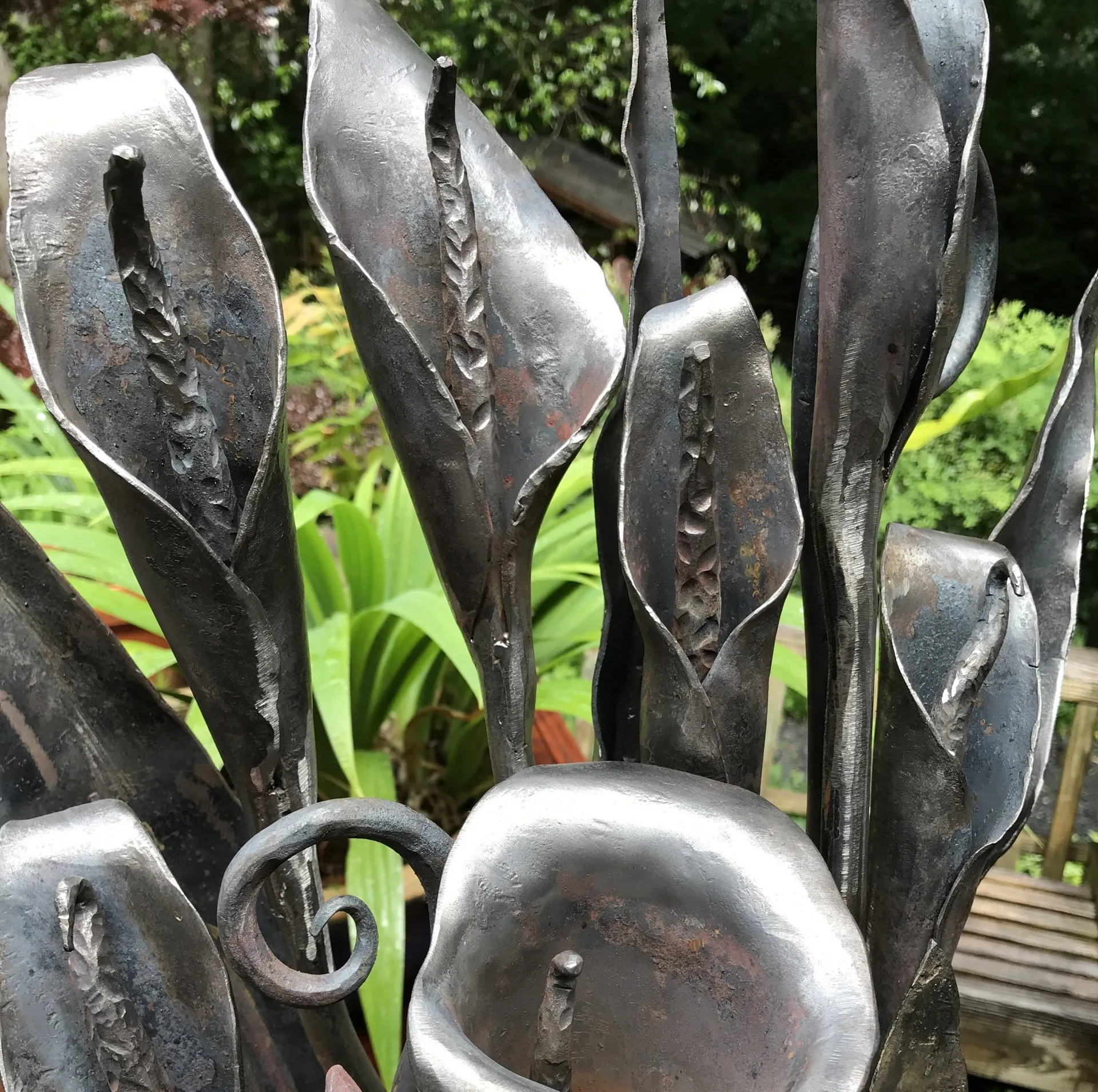A close up of a metal sculpture of flowers in a garden