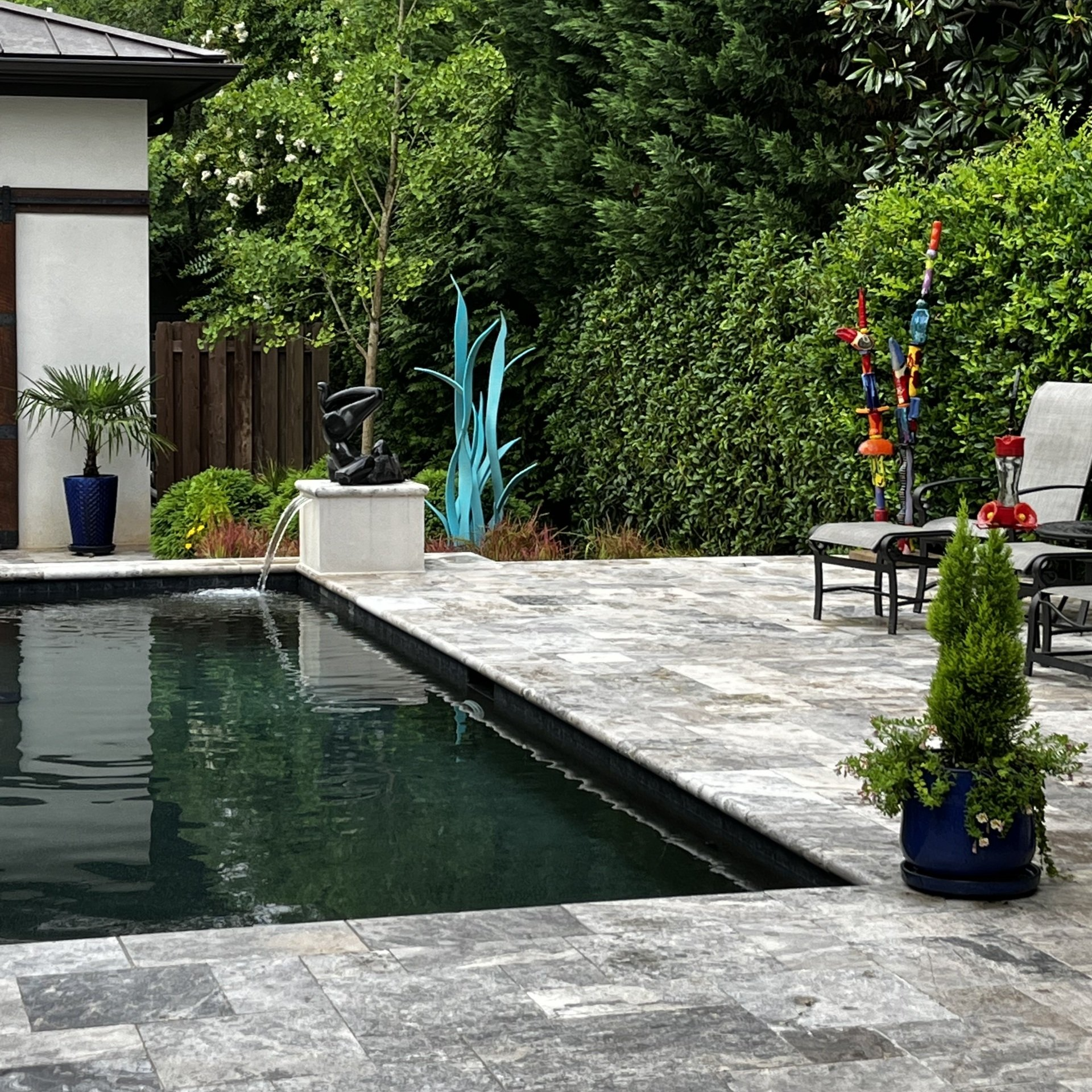 A large swimming pool surrounded by chairs and trees