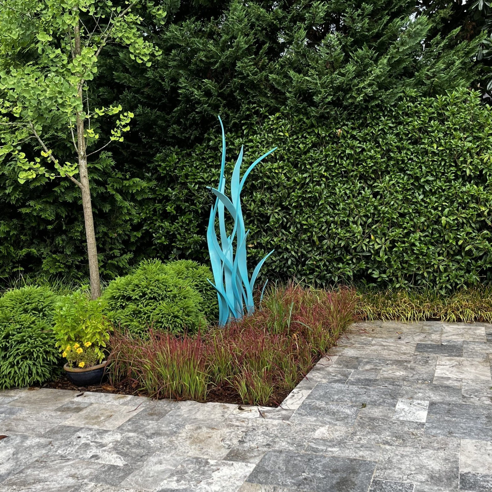 A garden with a blue sculpture in the middle of it