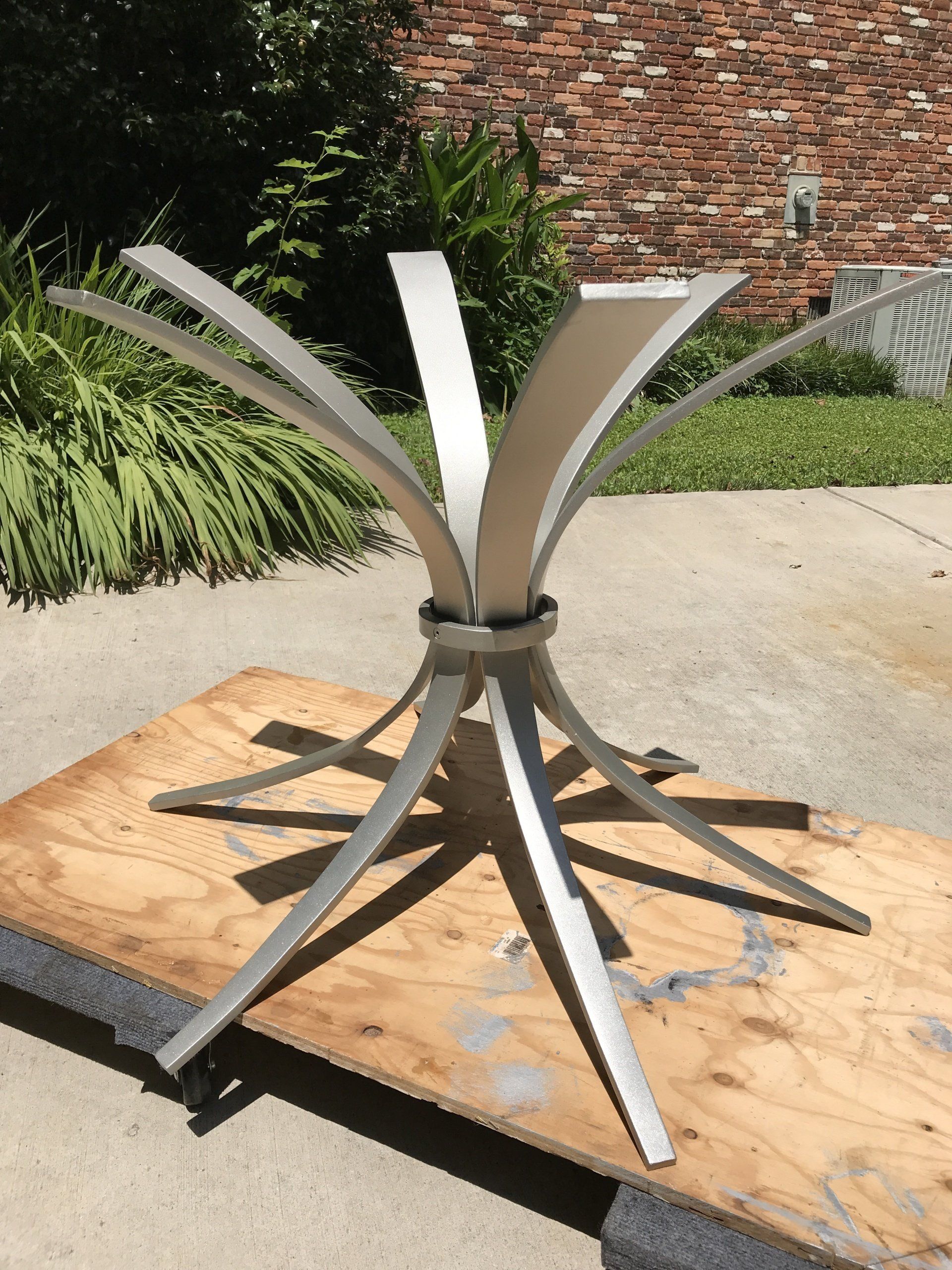 A stainless steel table base is sitting on a wooden table.
