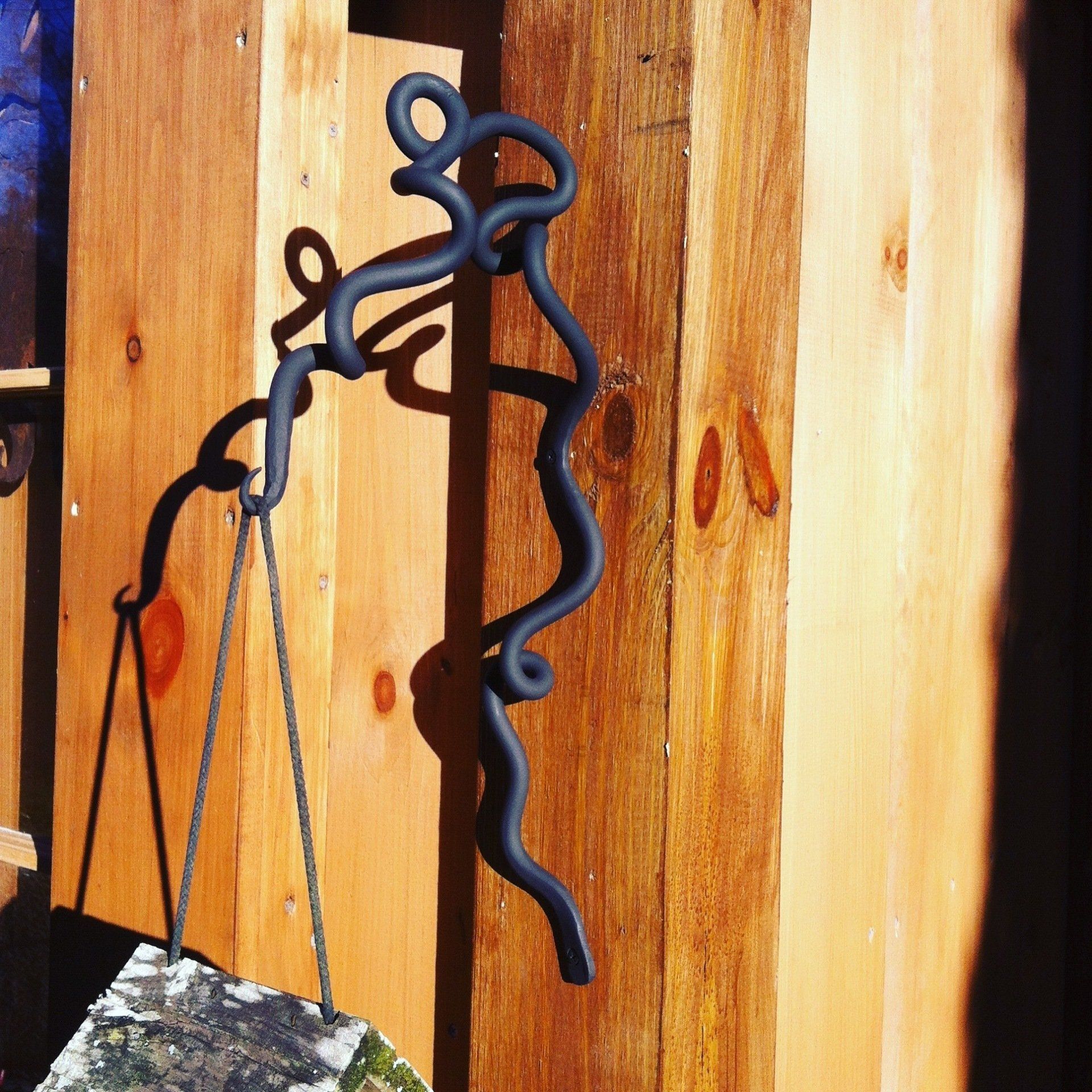 A sculpture of a person hanging on a wooden wall