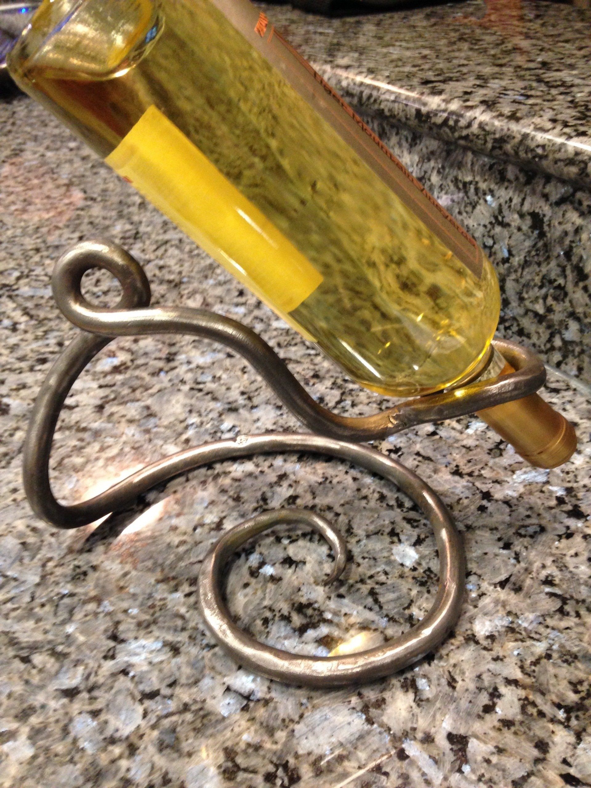 A bottle of wine is sitting on a metal stand