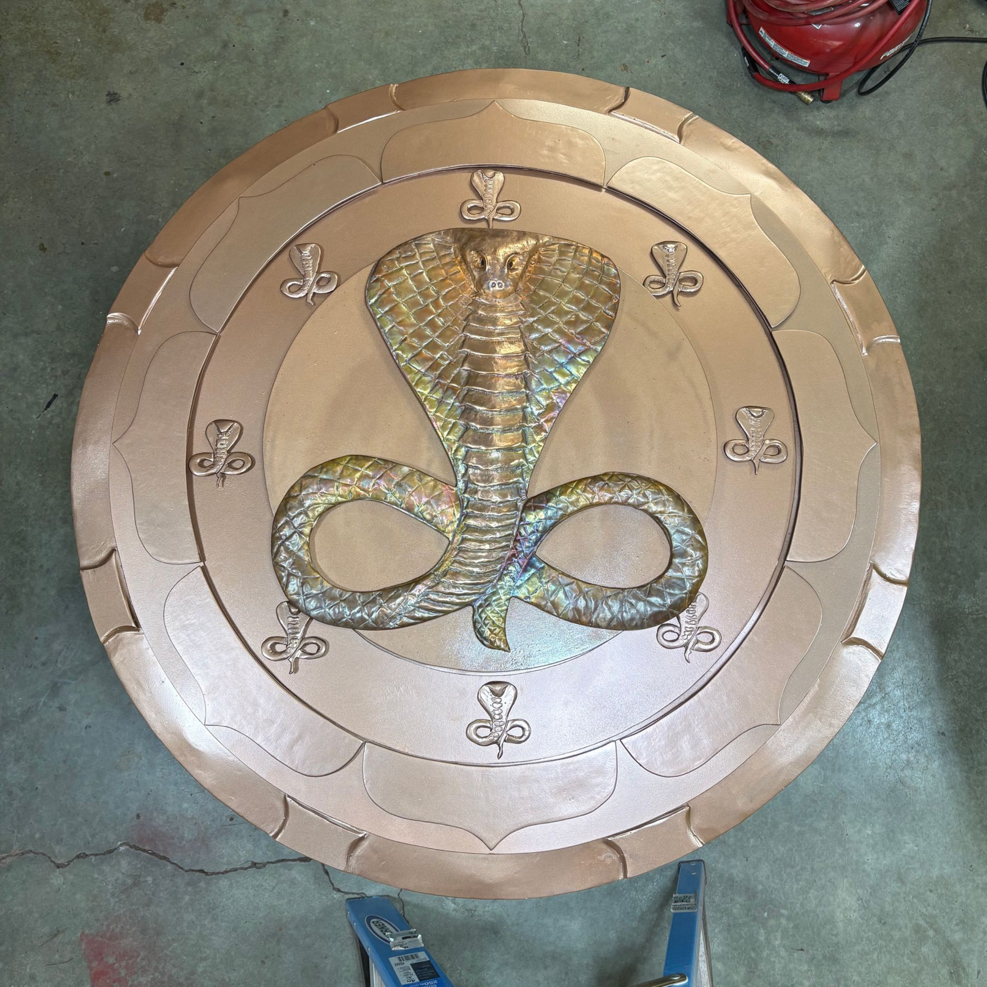 There is a fountain in the middle of the garden surrounded by trees.