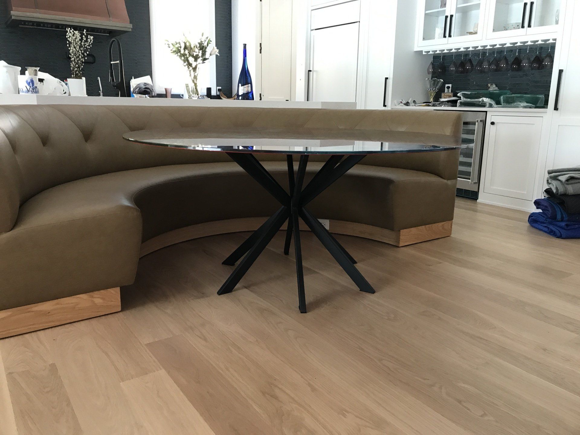 A kitchen with a round table and a curved bench