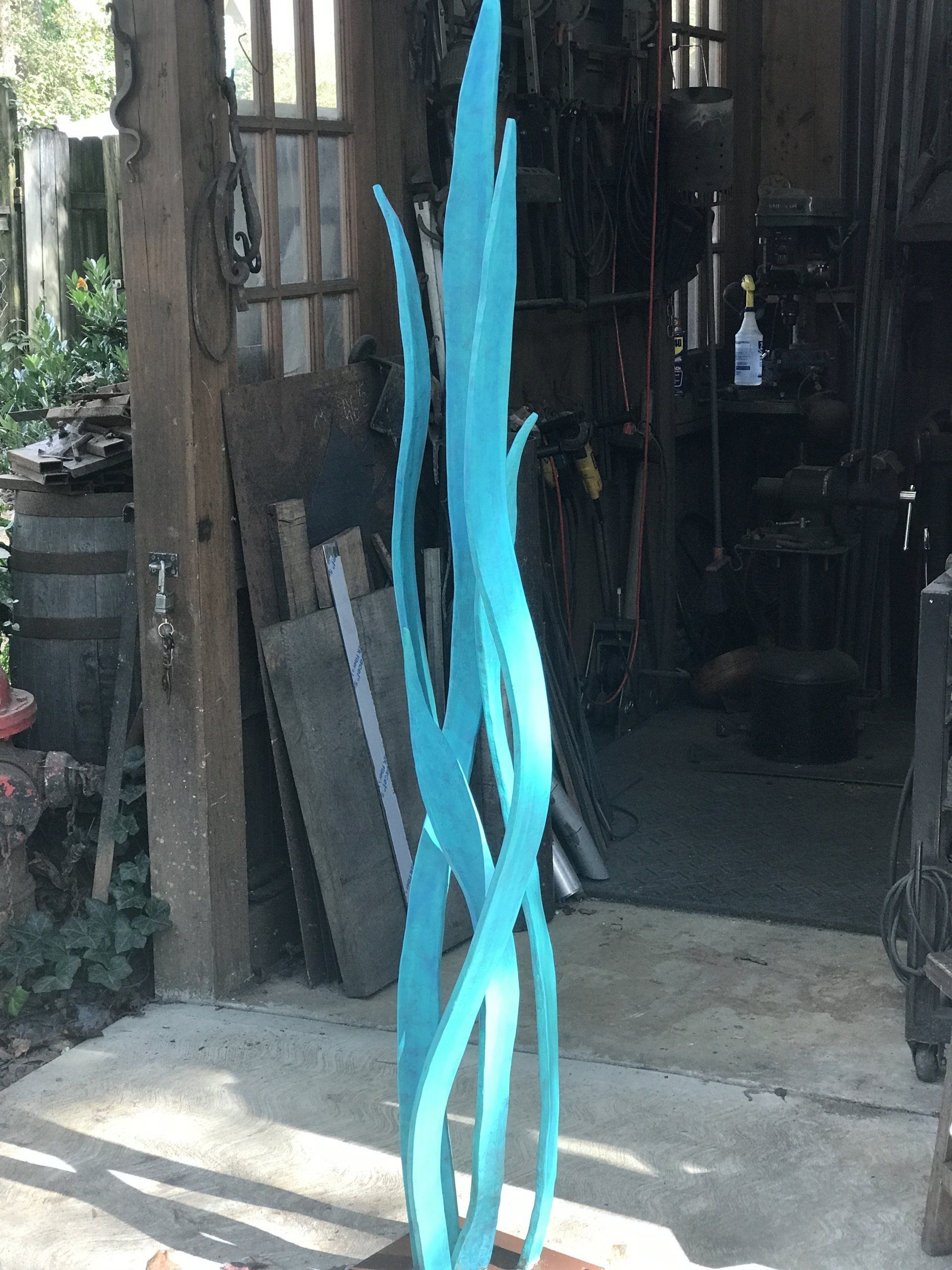 A large blue sculpture is sitting in front of a building.