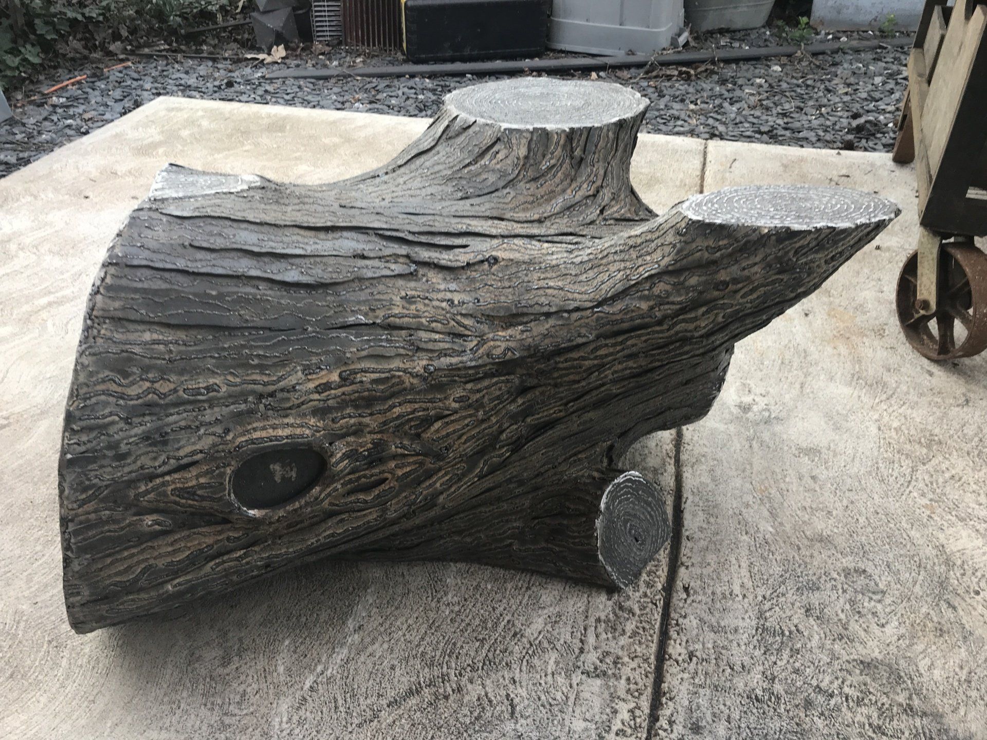 A large piece of wood is sitting on top of a concrete surface.