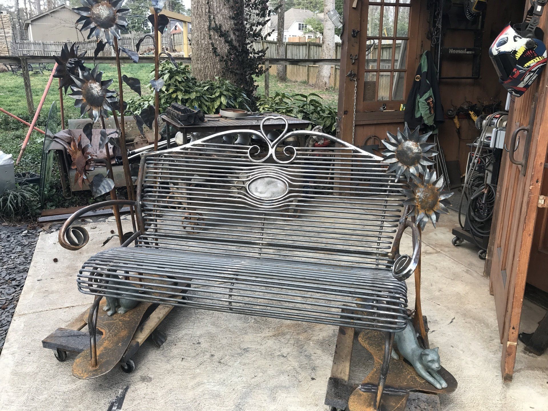 A wrought iron bench is sitting on top of a wooden table.