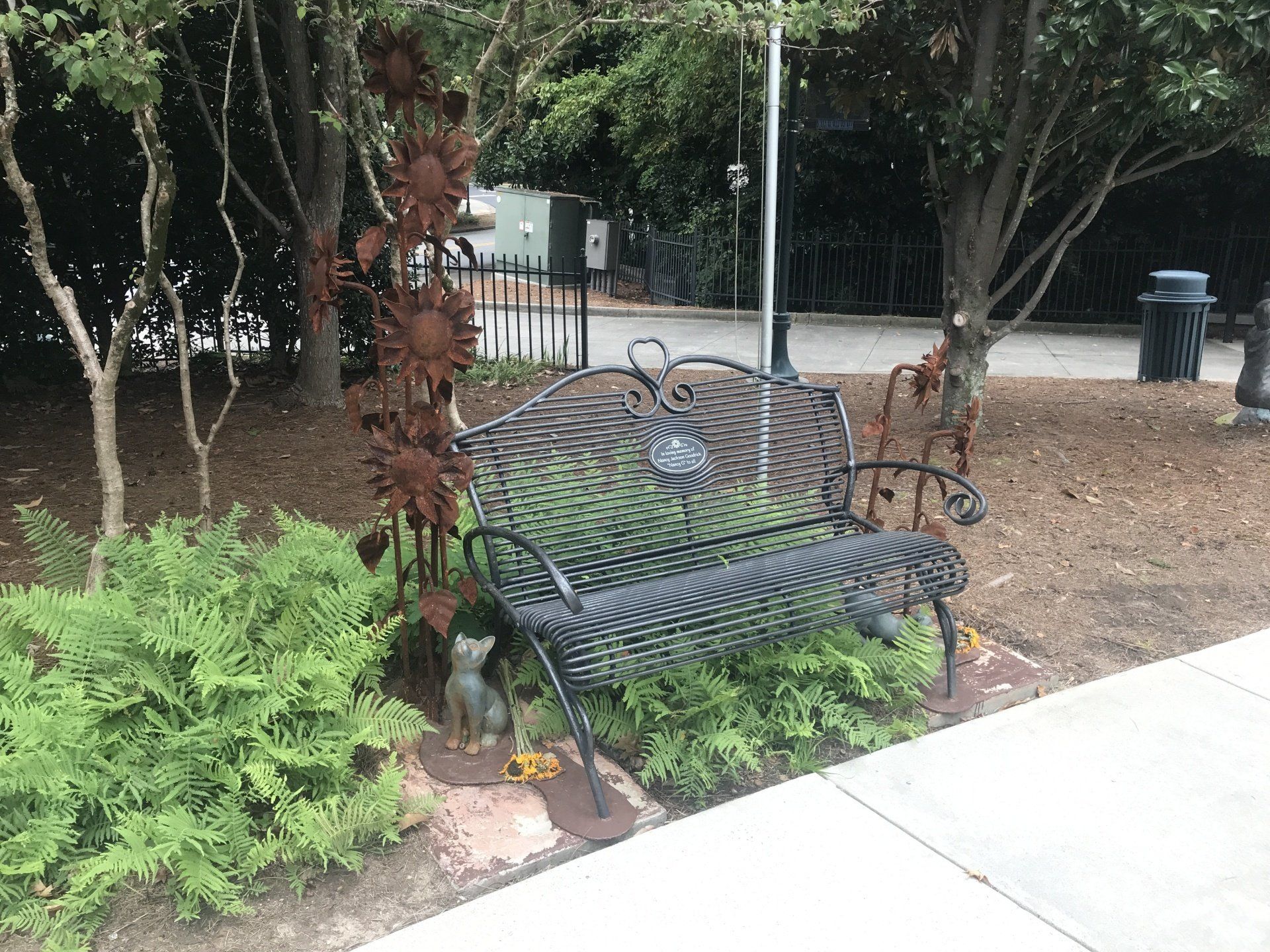 A park bench with a statue of a cat on it