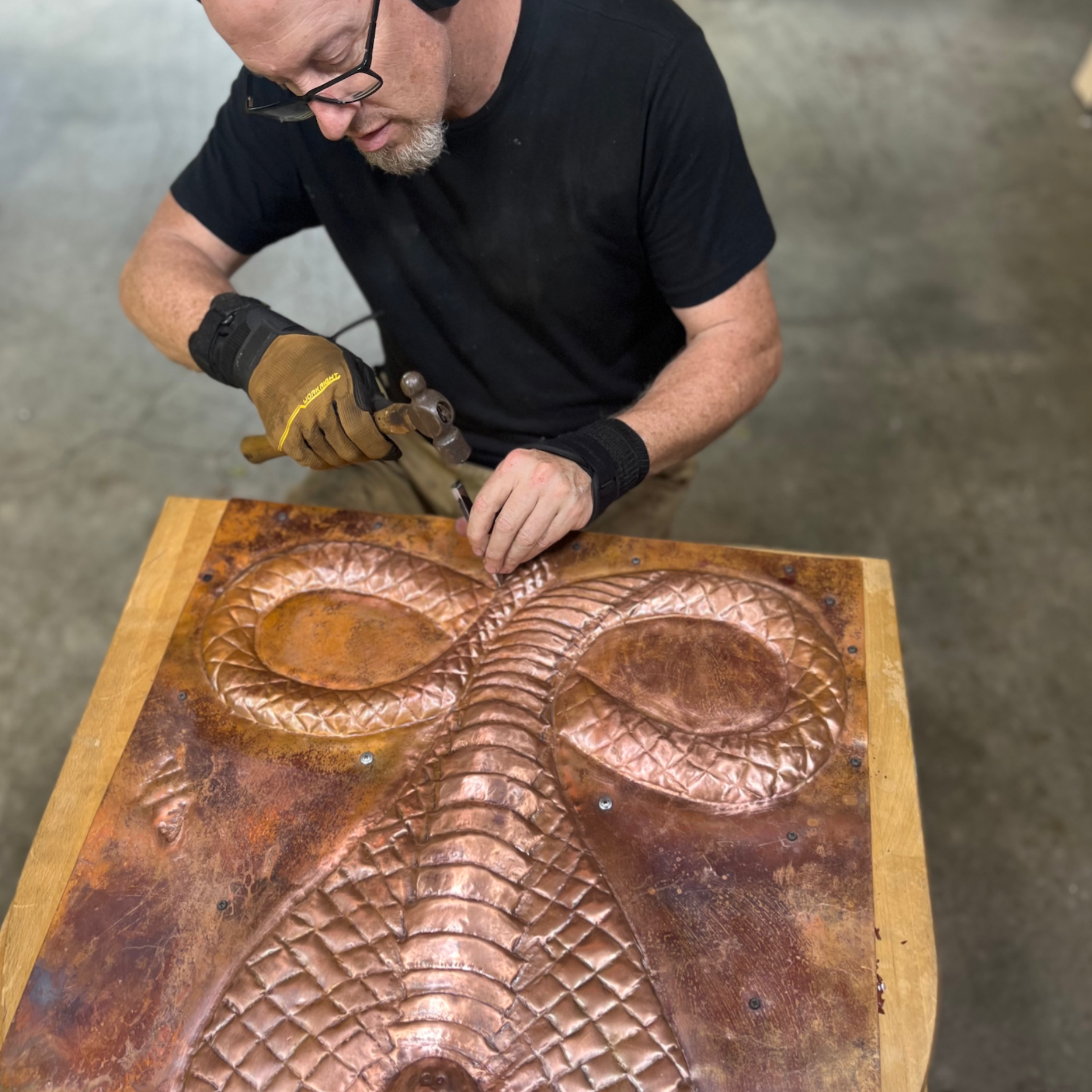 A large white house with green awnings is surrounded by trees and bushes.