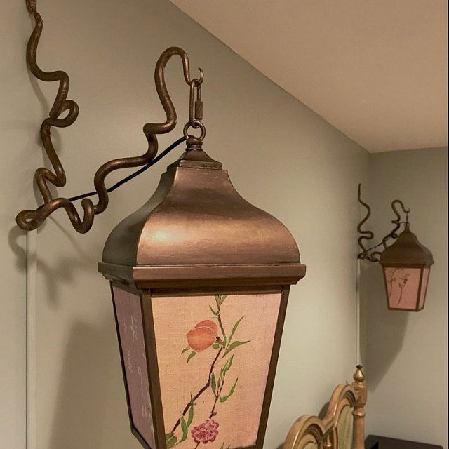A lantern with a floral design on it hangs from the ceiling