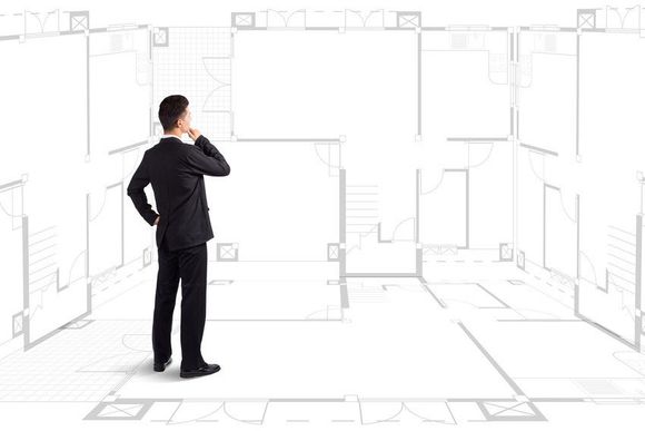 Businessman standing near a house blueprints; Shutterstock ID 175615595; PO: N/A; Job: BULK; Client: N/A; Other: BULK