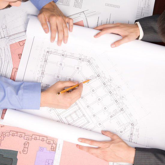 Architectural plans being drawn up, hands in shot