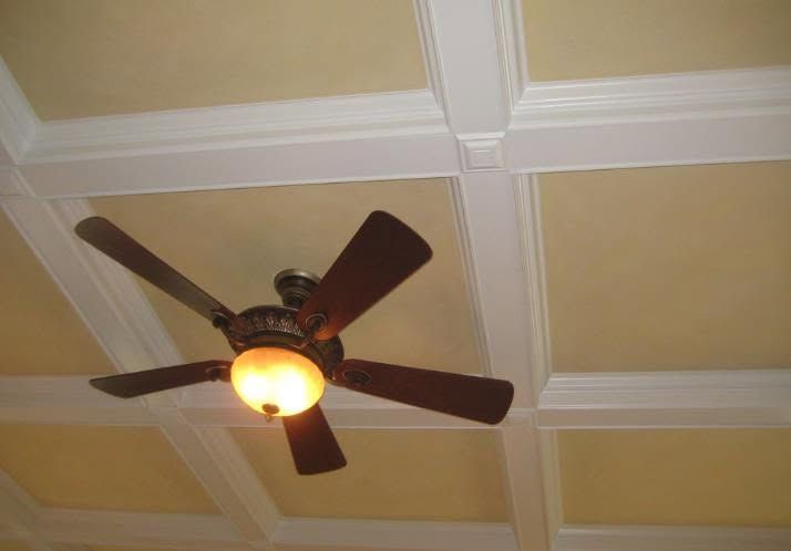 Ceiling fan with light on a beige coffered ceiling