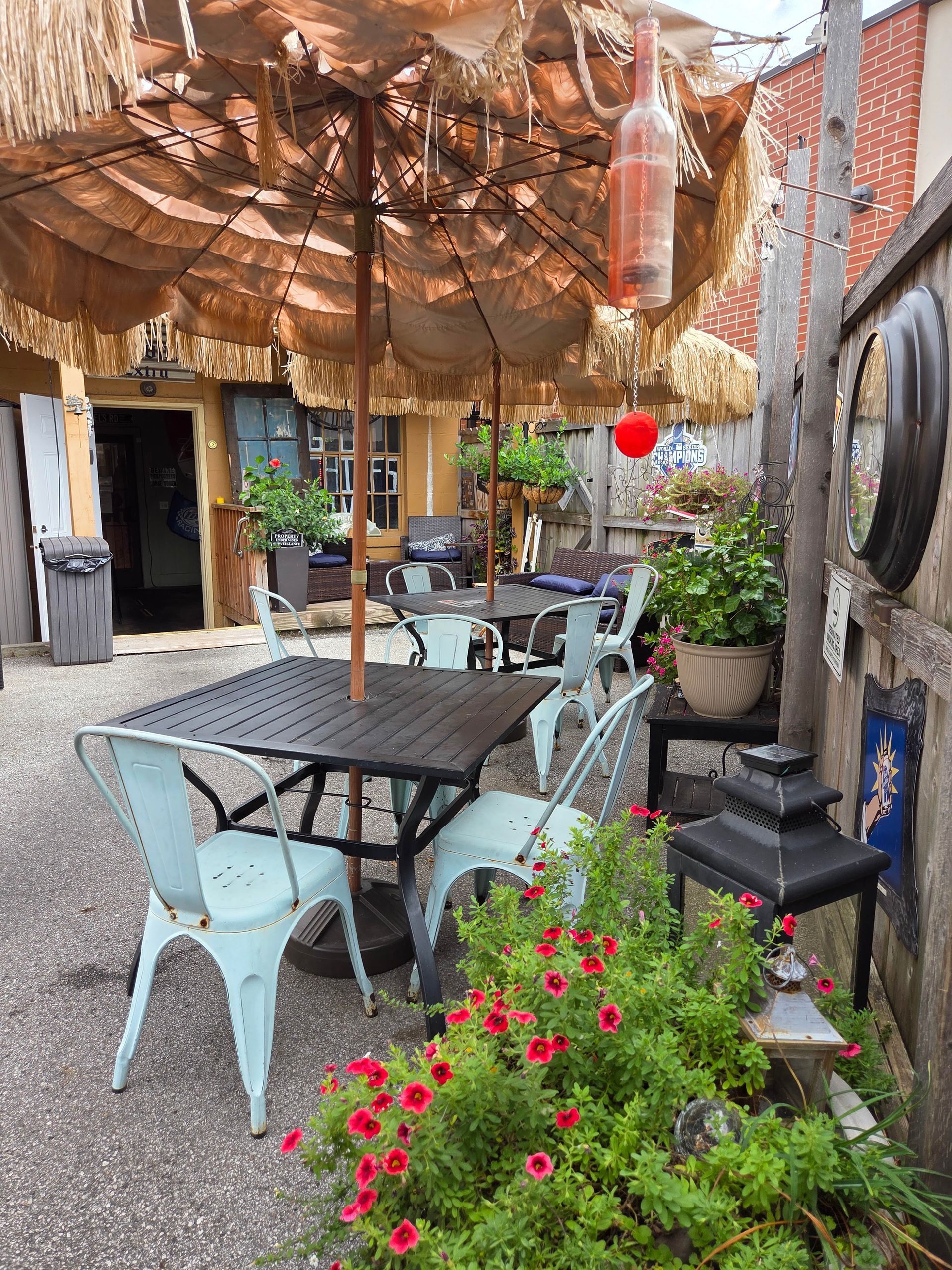 Outdoor seating area with tables, chairs, thatched umbrellas, and decorative plants. Outdoor seating area with tables, chairs, thatched umbrellas, and decorative plants.