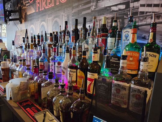 Bar with many liquor bottles on display, brightly lit. Bar with many liquor bottles on display, brightly lit.