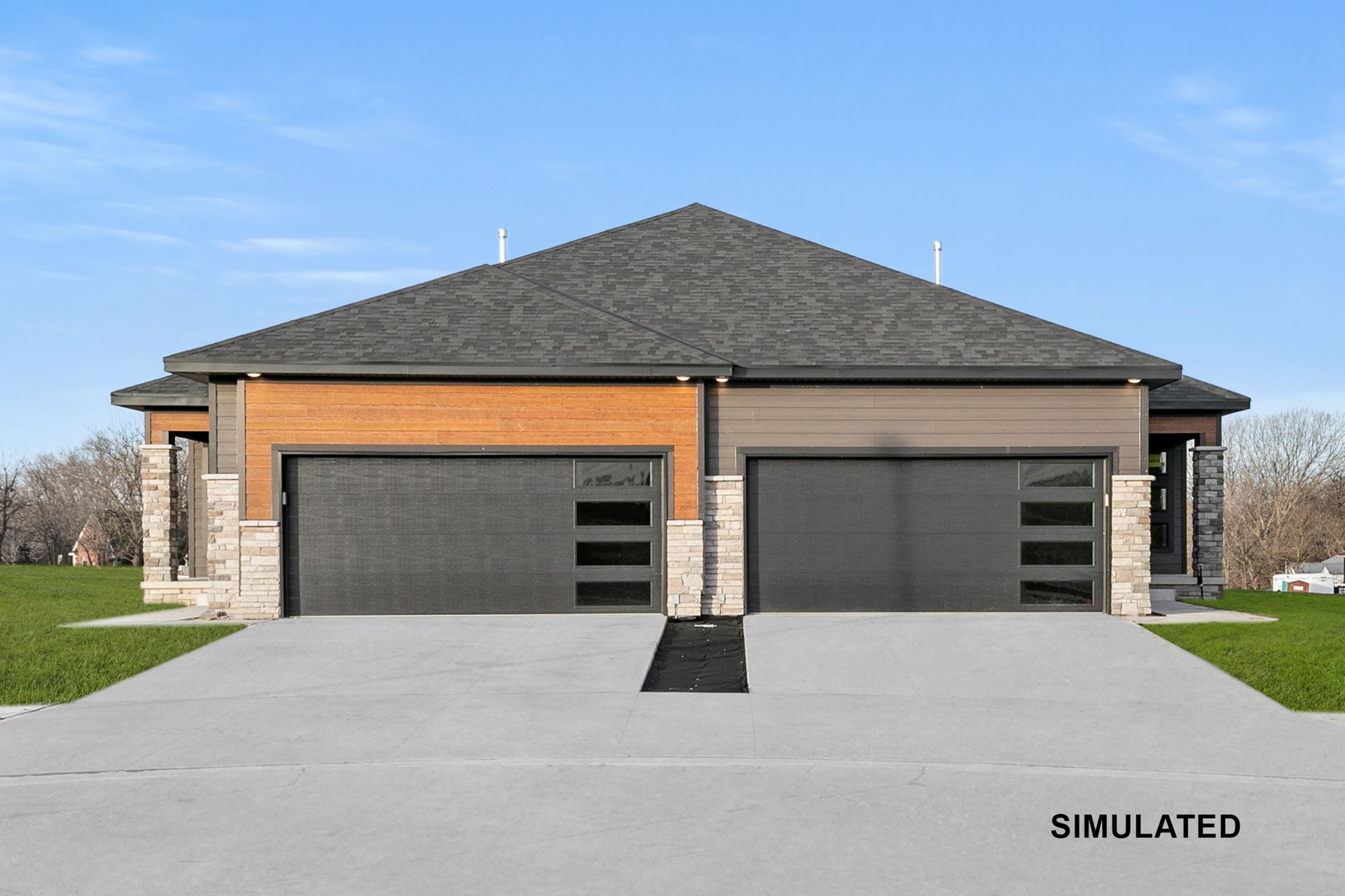 Duplex with gray garage doors and contrasting brick and siding, concrete driveway.