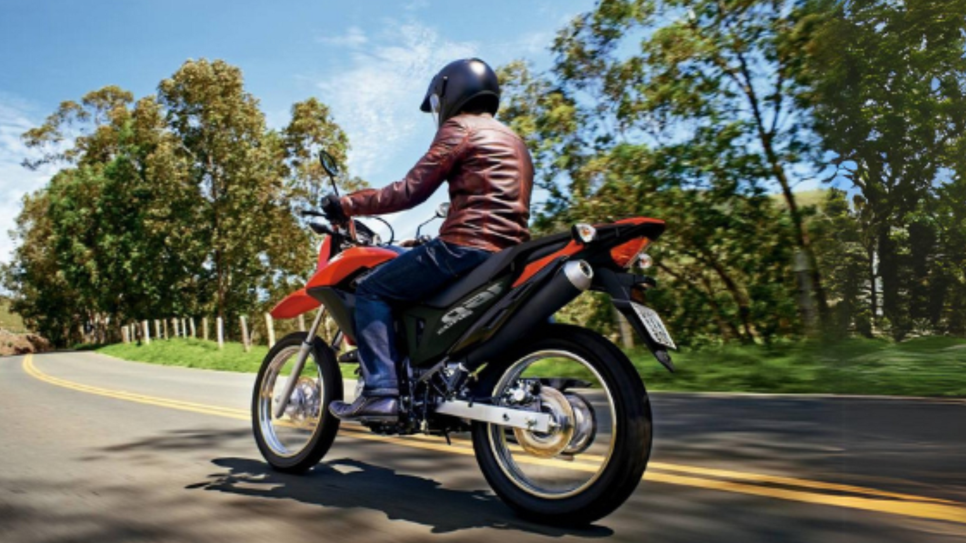 um homem está andando de moto por uma estrada.