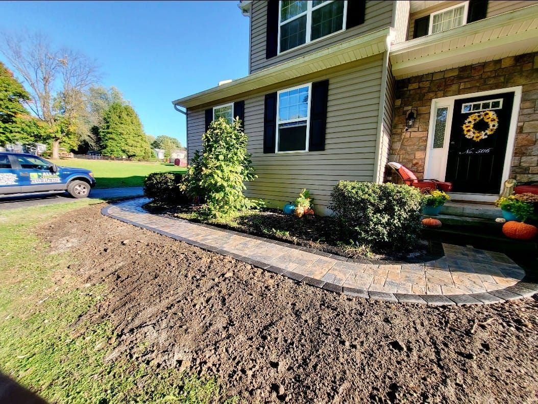 A house with a walkway and a truck parked in front of it.