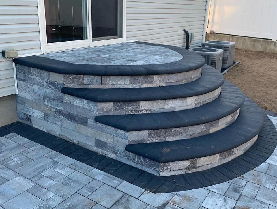 A set of stairs leading up to a patio in front of a house.