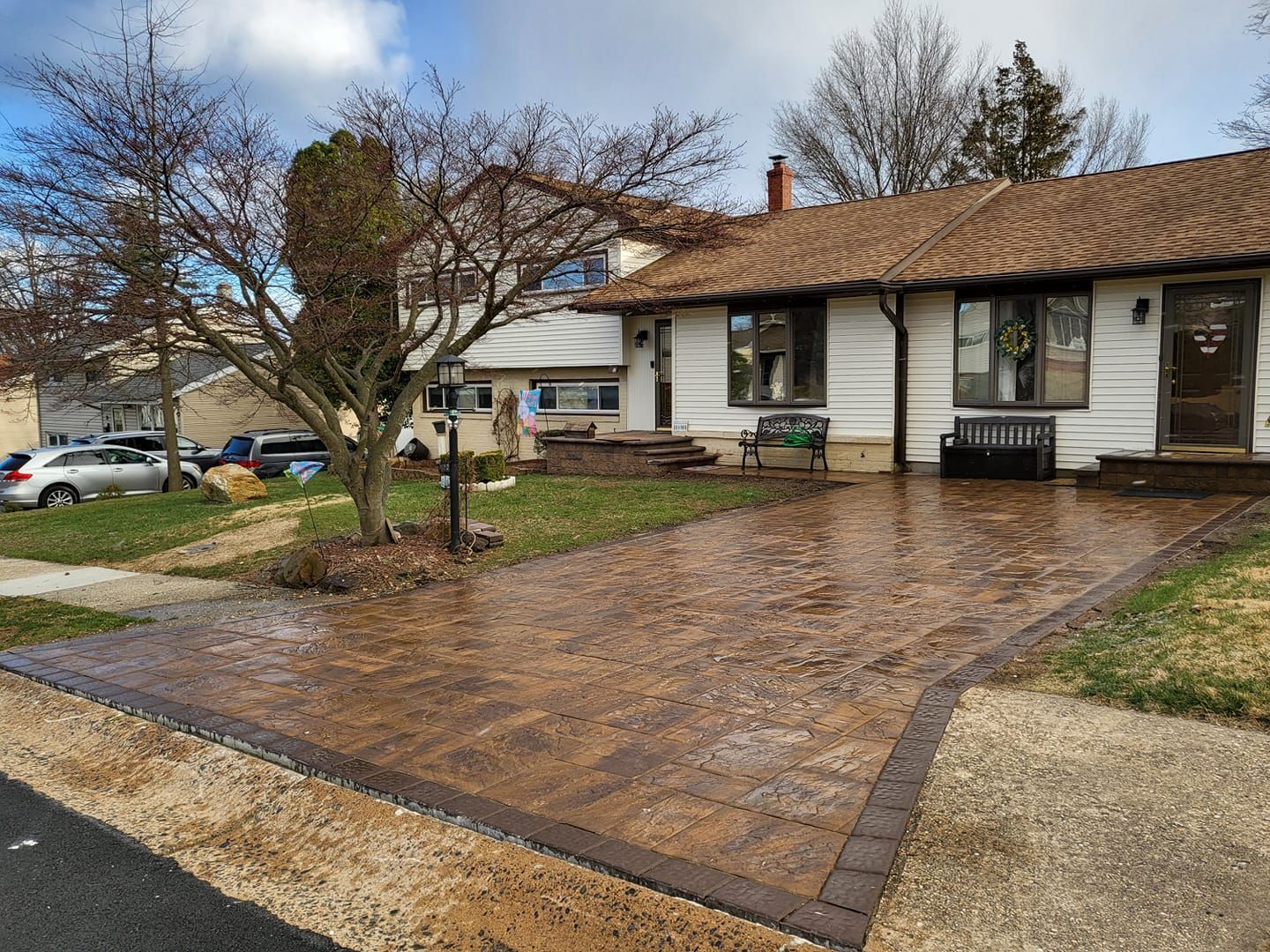 A house with a brick driveway in front of it.