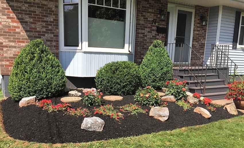 A brick house with a garden in front of it.