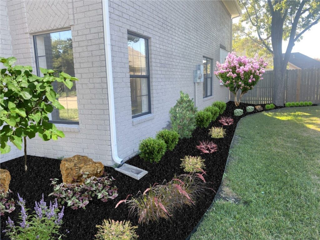 A white brick house with a lush green lawn and flowers in front of it.