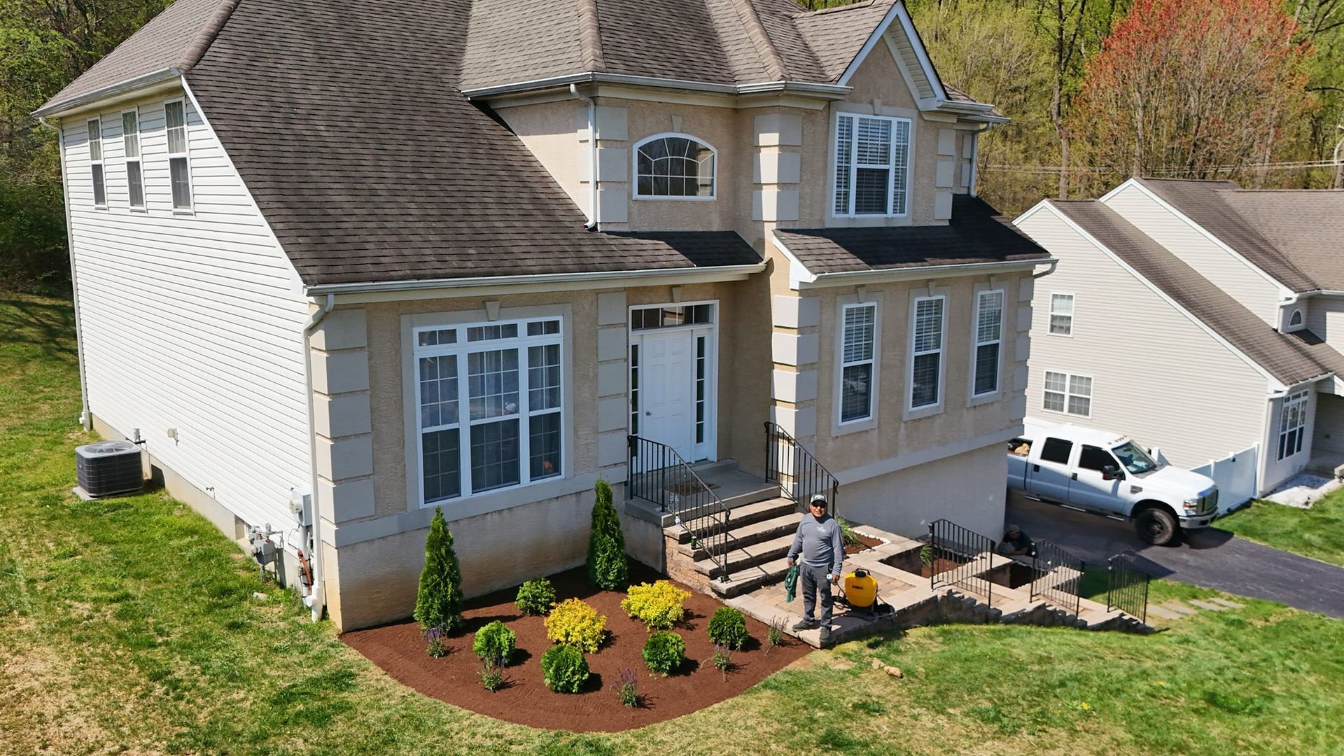 An aerial view of a house with a man standing in front of it.