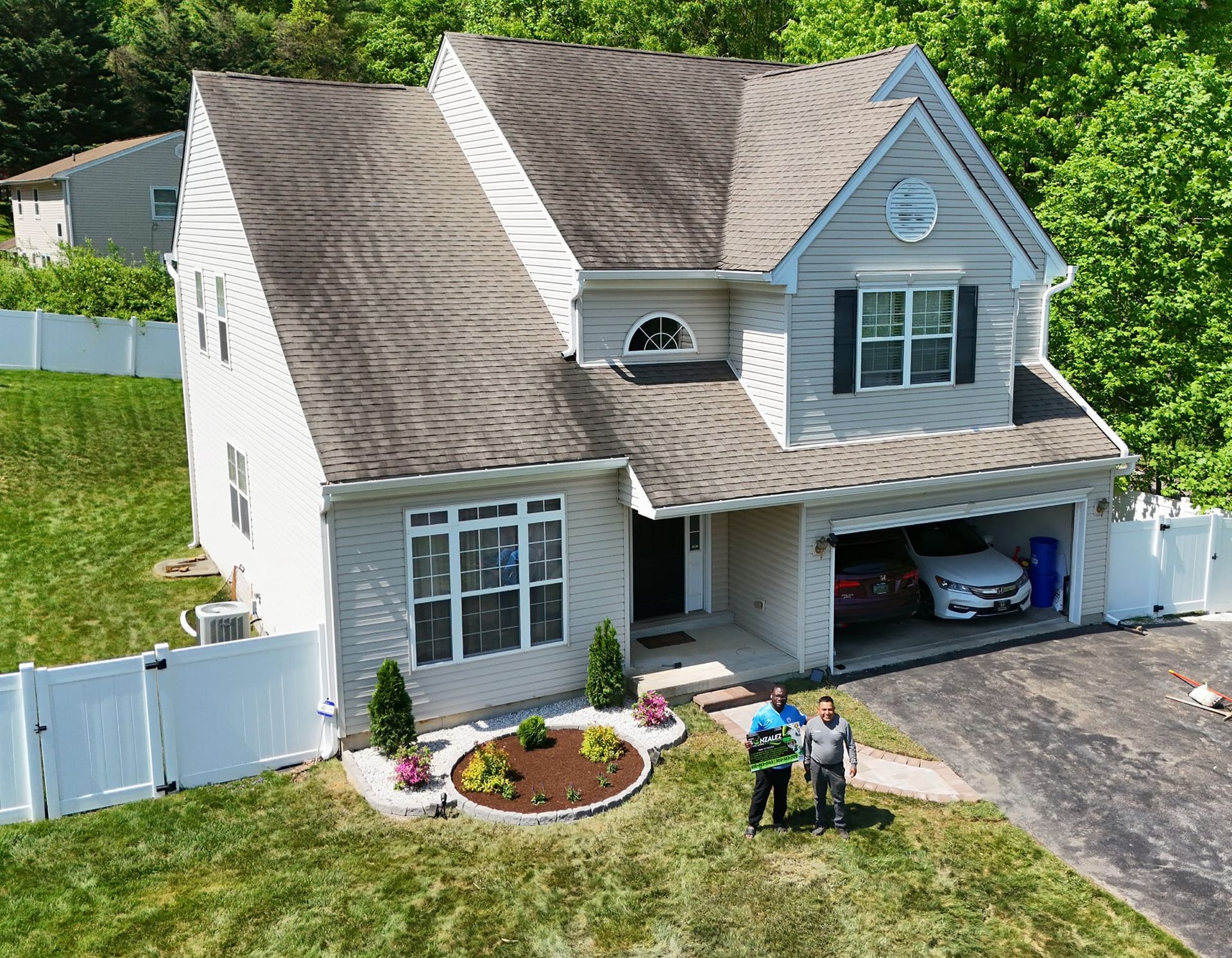 An aerial view of a house with two people standing in front of it.