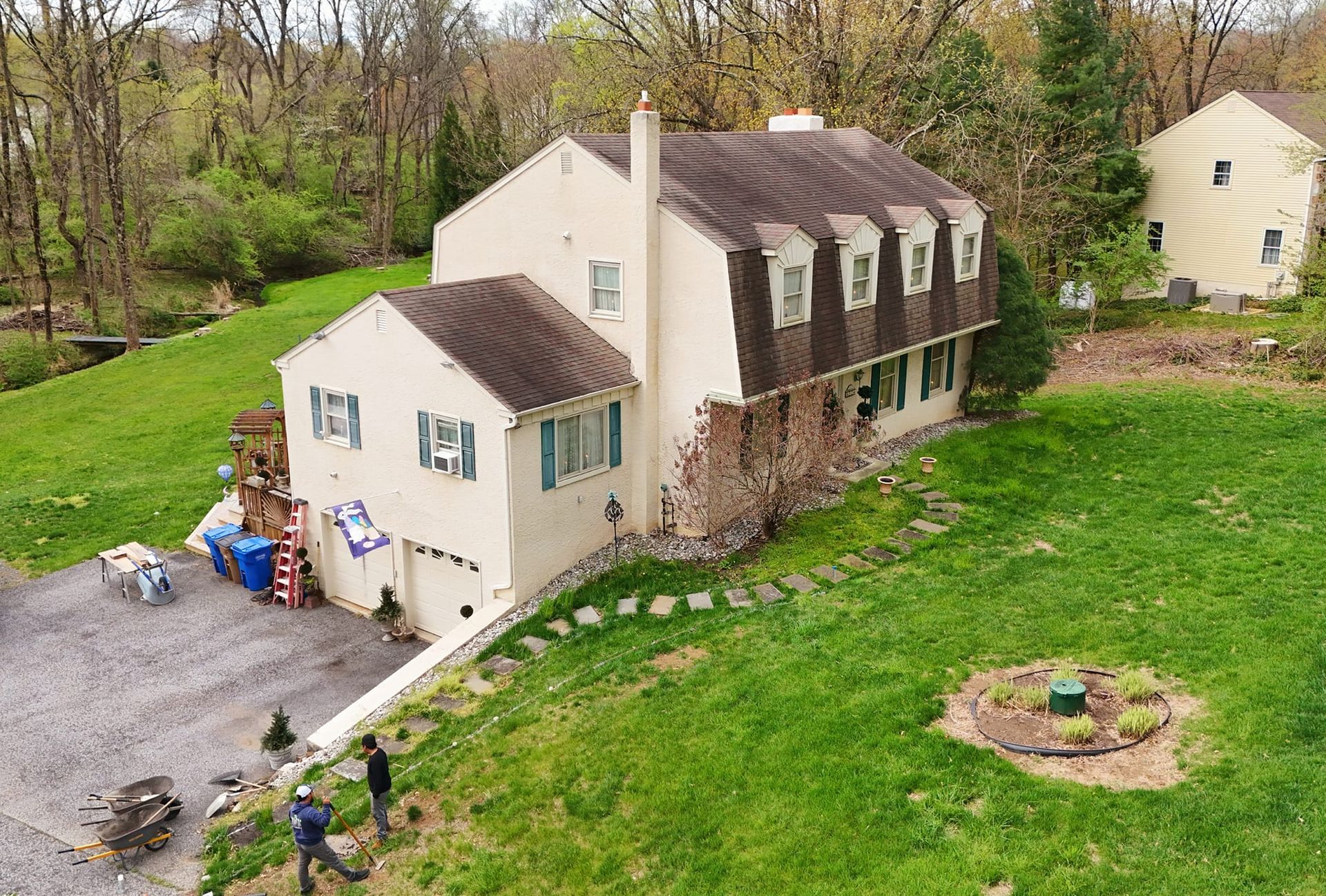 An aerial view of a house with a large lawn in front of it.