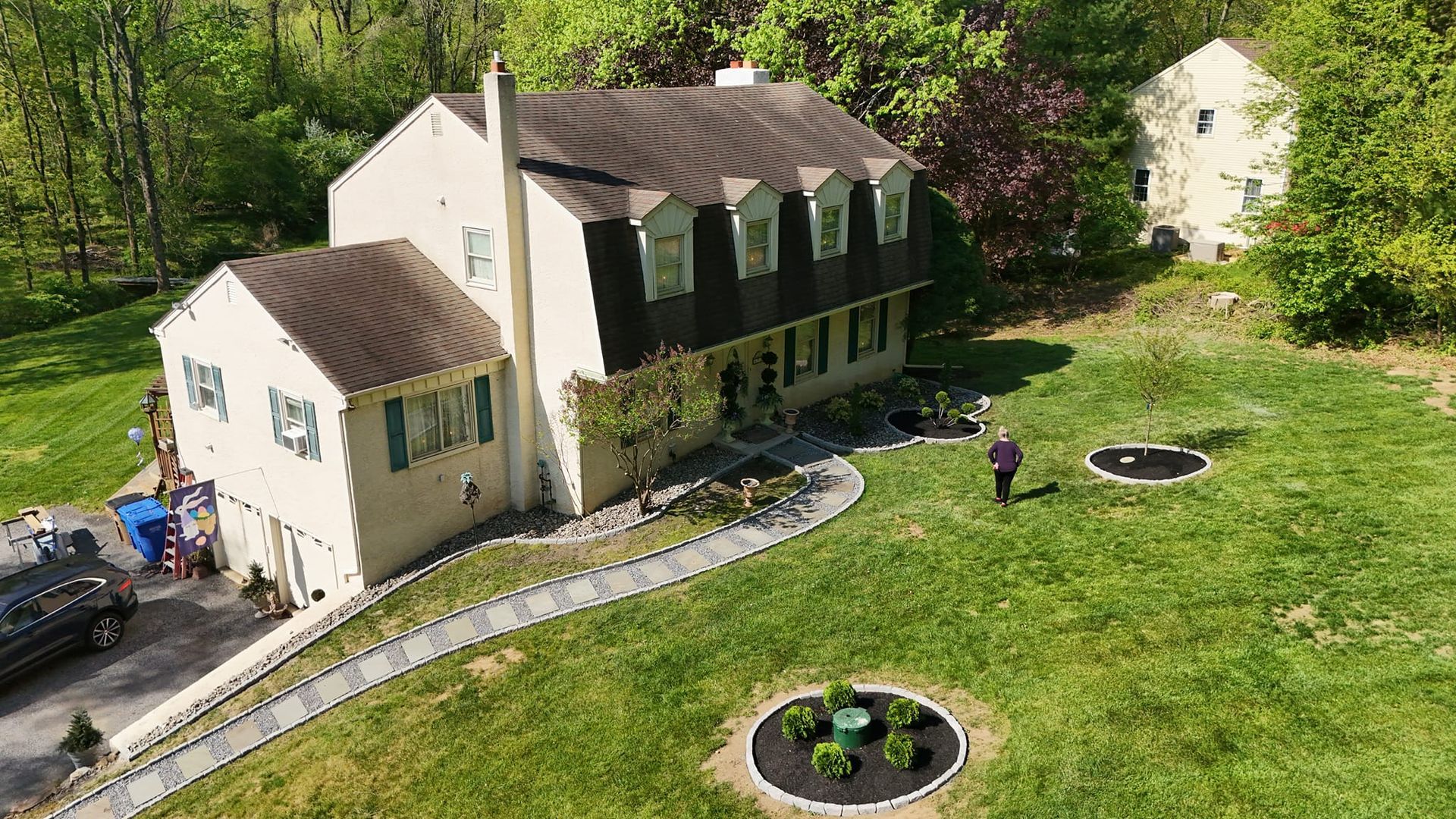 An aerial view of a large house with a large lawn in front of it.
