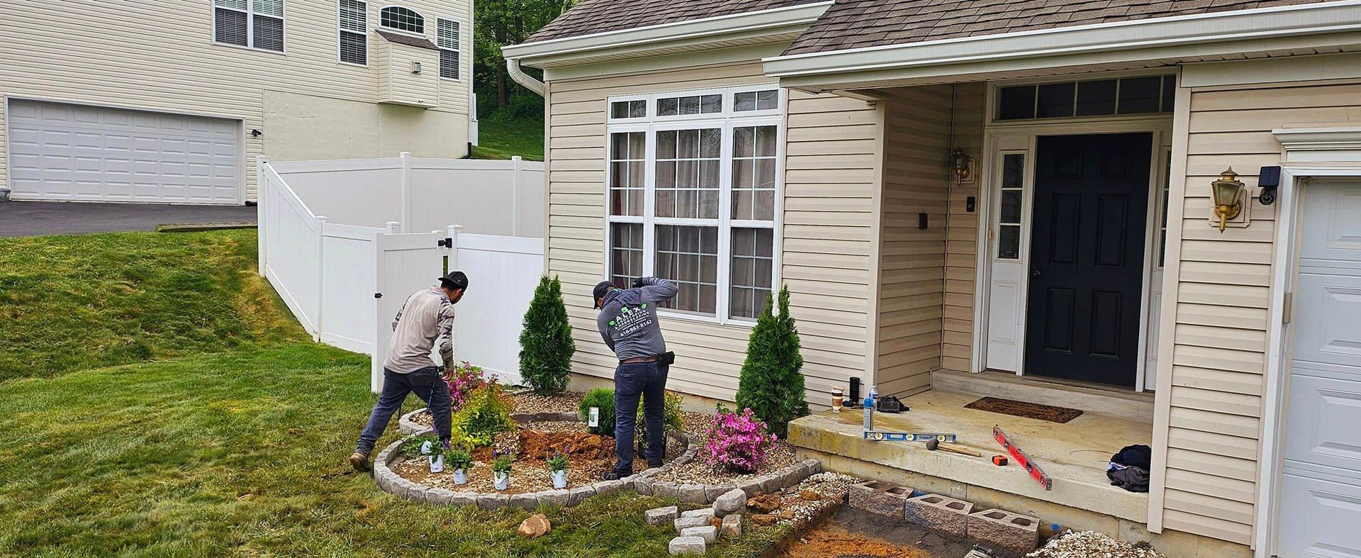 A couple of men are working on the front of a house.