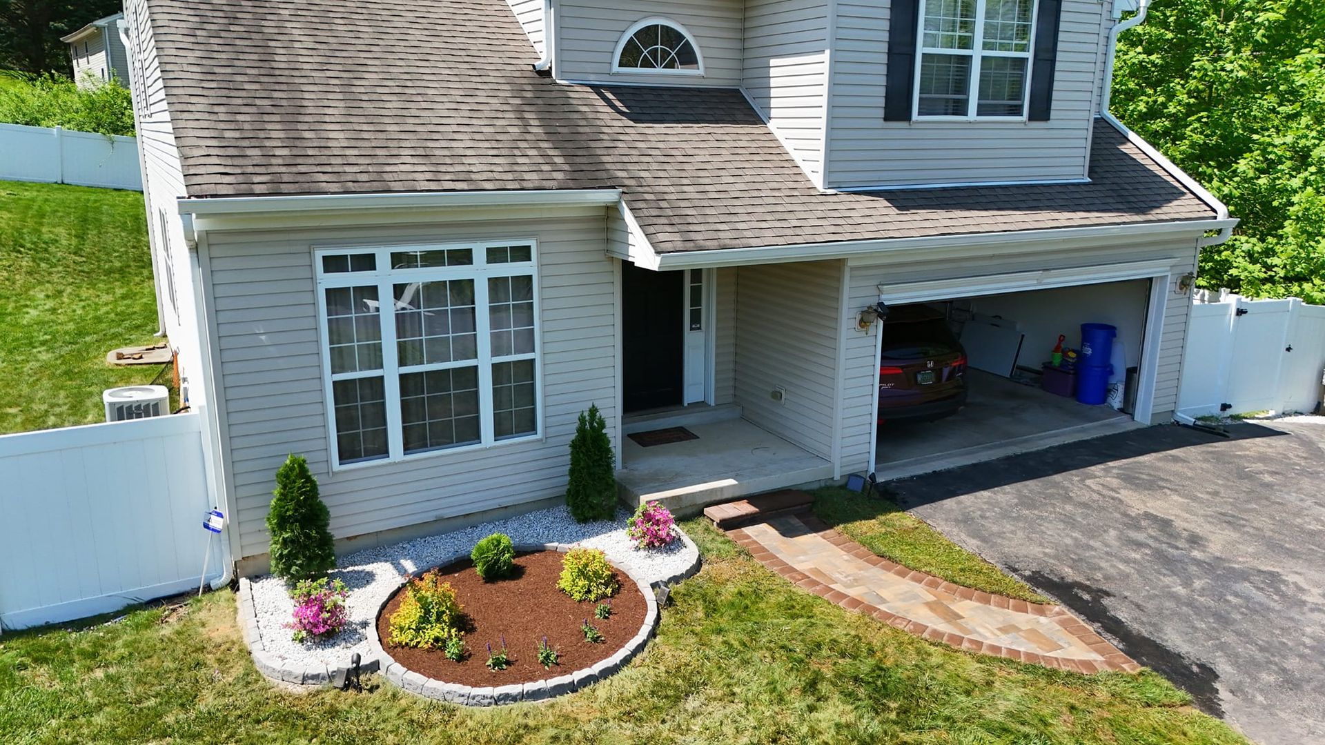 An aerial view of a house with a car parked in the garage.