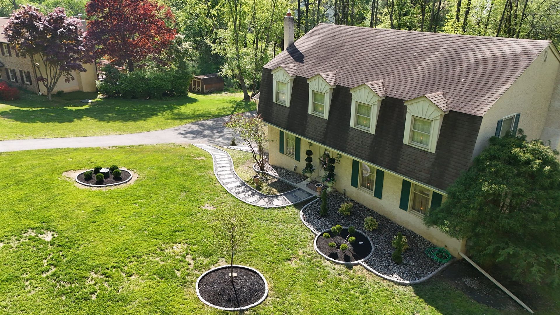 An aerial view of a large house with a large lawn in front of it.