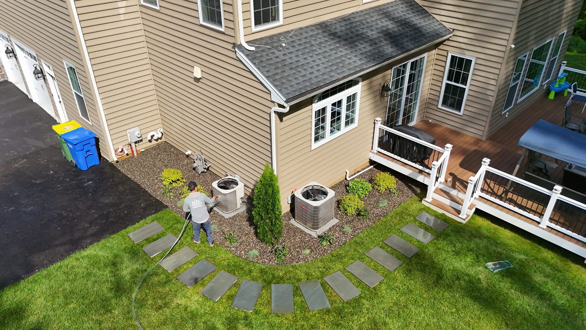 An aerial view of a house with a man standing in front of it.